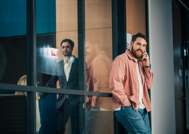 Мужчина разговаривает по телефону в коридоре офиса