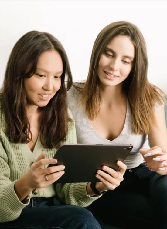 Две девушки смотрят в планшет